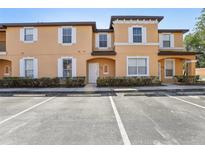 Two-story condo with parking in front, decorative shutters, and arched doorway at 2718 Bushman Dr, Kissimmee, FL 34746