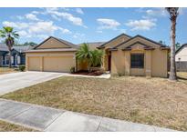 Inviting single-story home featuring a three-car garage, mature palm tree, and tidy front lawn at 2739 Village Pine Ter, Orlando, FL 32833
