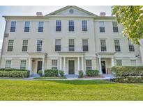 Elegant townhouse featuring a well-manicured lawn and classic architectural details at 312 Grand Bay Ln, Celebration, FL 34747