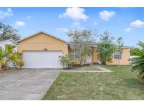 Charming single-story home featuring a well-maintained lawn and attached two-car garage at 4544 Point Look Out Rd, Orlando, FL 32808