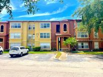Exterior view of the condo with balconies, manicured landscaping, and parking at 5160 Conroy Rd # 1423, Orlando, FL 32811