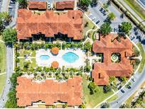 Stunning aerial view of community pool, landscaping, parking, and red tiled roofs at 5566 Metrowest Blvd # 304, Orlando, FL 32811
