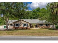 Charming single-story home featuring a well-manicured lawn and beautiful mature trees at 694 Tuscora Dr, Winter Springs, FL 32708