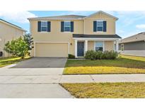 Charming two-story home featuring a two-car garage, well-maintained lawn, and inviting front porch at 740 Simone Ct, Haines City, FL 33844