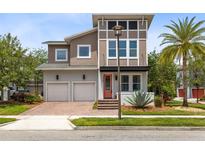 Contemporary two-story home with a red door, a two-car garage, and a well-manicured lawn at 8263 Bellow St, Orlando, FL 32827