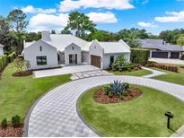 Stunning home featuring a circular driveway, elegant landscaping, and a three-car garage at 9364 Thurloe Pl, Orlando, FL 32827