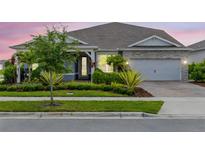 Charming single-story home with well-manicured landscaping, stone accents, and an attached two-car garage at 13807 Tybee Beach Ln, Orlando, FL 32827