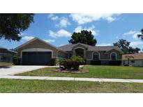 Charming single-story home featuring a well-manicured lawn and attached two-car garage at 15910 Mercott Ct, Clermont, FL 34714