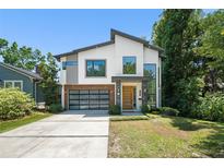 Stunning modern home featuring a glass garage door, crisp white accents, and professional landscaping at 1624 E Livingston St, Orlando, FL 32803