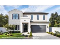 Modern two-story home with brick and stucco exterior, black framed windows, and attached two-car garage at 2612 Musselwhite Ave, Orlando, FL 32804
