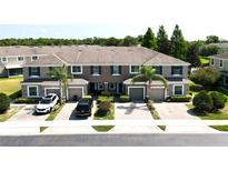 Charming townhome exterior featuring a brick driveway, tidy landscaping, and a neutral color palette at 2656 River Landing Dr, Sanford, FL 32771