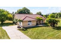 Charming single-story home with a well-manicured lawn, tiled roof, and a long driveway at 2726 La Alameda Ave, Kissimmee, FL 34746
