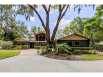 Charming single-story home featuring a large, mature tree in the front yard and an inviting driveway at 3359 Scarlet Dr, Sanford, FL 32773