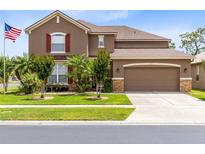 Charming two-story home with a well-manicured lawn, beautiful landscaping, and a spacious two-car garage at 613 Crownclover Ave, Orlando, FL 32828