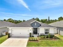 Charming single-story home featuring a manicured lawn, two-car garage, and inviting front entrance at 62 Polermo Ave, St Cloud, FL 34771