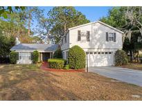 Charming two-story home featuring mature landscaping and a well-maintained front yard and a two-car garage at 7470 Lake Marsha Dr, Orlando, FL 32819