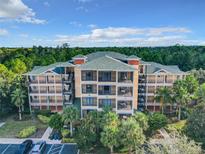 Beautiful multi-story condo building featuring a lovely green roof, balconies, and well-maintained landscaping at 9061 Treasure Trove Ln # 403, Kissimmee, FL 34747