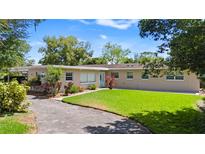 Charming single-story home featuring a well-manicured lawn, mature landscaping, and a welcoming entrance at 101 E Lauren Ct, Fern Park, FL 32730