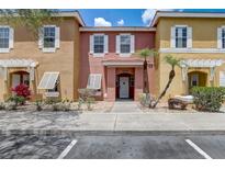 Inviting townhome featuring colorful exteriors, manicured landscaping, and a charming front entrance at 1041 Park Ridge Cir, Kissimmee, FL 34746