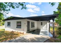 Charming single-story home with a covered front porch and well-maintained landscaping at 13 Fanfair Ave, Orlando, FL 32811