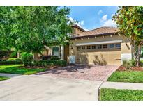 Beautiful home exterior with a red brick driveway and well-manicured landscaping at 1300 Island Green St, Davenport, FL 33896