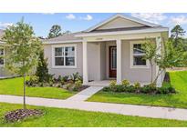 Charming single-story home with manicured lawn, landscaped garden beds, and inviting covered entry with white columns at 13082 Pergola Ave, Orlando, FL 32832