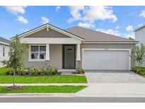 Charming single-story home featuring a two-car garage, manicured lawn, and inviting front entrance with stone accents at 13248 Pergola Ave, Orlando, FL 32832