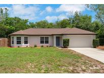 Charming single-story home with manicured lawn, bay window, mature landscaping, and two-car garage at 1861 E Glancy Dr, Deltona, FL 32725