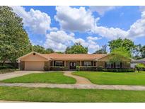 Charming single-story home featuring a well-manicured lawn and inviting front entrance at 413 Sandy Hill Dr, Longwood, FL 32779
