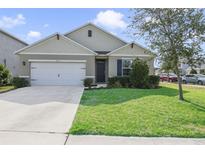 Charming single-story home with a well-maintained lawn and attached two-car garage at 415 Anne St, Deland, FL 32724