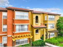 Exterior view of multi-Gathering home with orange and yellow stucco and clay tile roof at 5164 Conroy Rd # 1526, Orlando, FL 32811