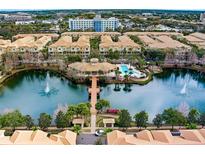 Beautiful aerial view of community pool, lake with fountain, and well-maintained grounds, surrounded by townhomes and buildings at 724 Greybull Run, Lake Mary, FL 32746
