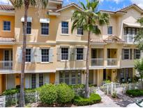 Charming multi-story townhome with palm trees, a white fence, and a well-maintained front yard at 724 Greybull Run, Lake Mary, FL 32746
