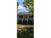 Charming home featuring a bright yellow front door, a cozy porch and a well-maintained lawn at 9315 9Th Ave, Orlando, FL 32824