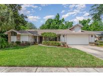 Charming single-story home featuring a well-manicured lawn and a two-car garage at 1100 Oday Dr, Winter Springs, FL 32708