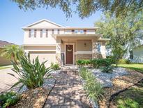 Inviting two-story home featuring manicured landscaping and a welcoming front porch, complete with an attached two car garage at 11742 Chateaubriand Ave, Orlando, FL 32836