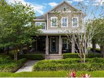 Charming two-story home with covered front porch, stone accents, and lush landscaping creating curb appeal at 14025 Hench Ln, Orlando, FL 32827