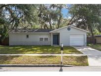 Charming single-story home with well-maintained lawn, blue door, and a one car garage at 2935 Arcata Ln, Orlando, FL 32817