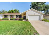 Charming single-story home featuring a manicured lawn and an attached two-car garage at 307 Coble Dr, Longwood, FL 32779