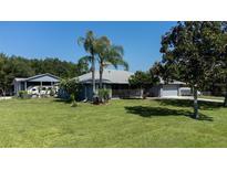 Landscaped yard with charming one-story home, detached garage, and RV parking on a sunny day at 4170 Packard Ave, St Cloud, FL 34772