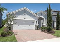 Charming single-Gathering home with a manicured lawn and brick driveway leading to a spacious two-car garage at 4548 Dulwik Pl, Sanford, FL 32771