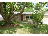 Charming single-story home featuring a stone facade, mature trees, and a well-manicured lawn at 622 Alton Rd, Winter Springs, FL 32708