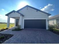 Charming single-story home featuring a two-car garage and inviting covered entry at 734 Via Como St, Poinciana, FL 34759
