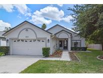 Charming single-story home featuring a two-car garage, a well-manicured lawn, and inviting front entrance at 1003 Hart Branch Dr, Oviedo, FL 32765