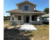 Charming two-story home featuring a cozy front porch with arched entryways and a freshly poured concrete walkway at 1310 Polk City Rd, Haines City, FL 33844
