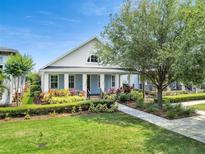 Charming home featuring a landscaped front yard, welcoming porch, and beautiful architectural details at 13662 Behring Ave, Orlando, FL 32827
