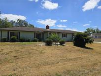 Charming one-story home featuring a well-maintained lawn and attractive landscaping under a bright blue sky at 1872 N Akron Dr, Deltona, FL 32738