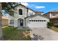 Charming two-story home with attached two car garage and well-manicured lawn at 2806 Polson Dr, Kissimmee, FL 34758