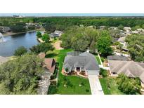 Beautiful aerial view of a home with lush landscaping, a screened pool, and a serene lake in the background at 3534 Woodley Park Pl, Oviedo, FL 32765