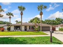 Charming single-story home with lush landscaping and a well-manicured lawn and mature palm trees at 5162 Tellson Pl, Orlando, FL 32812